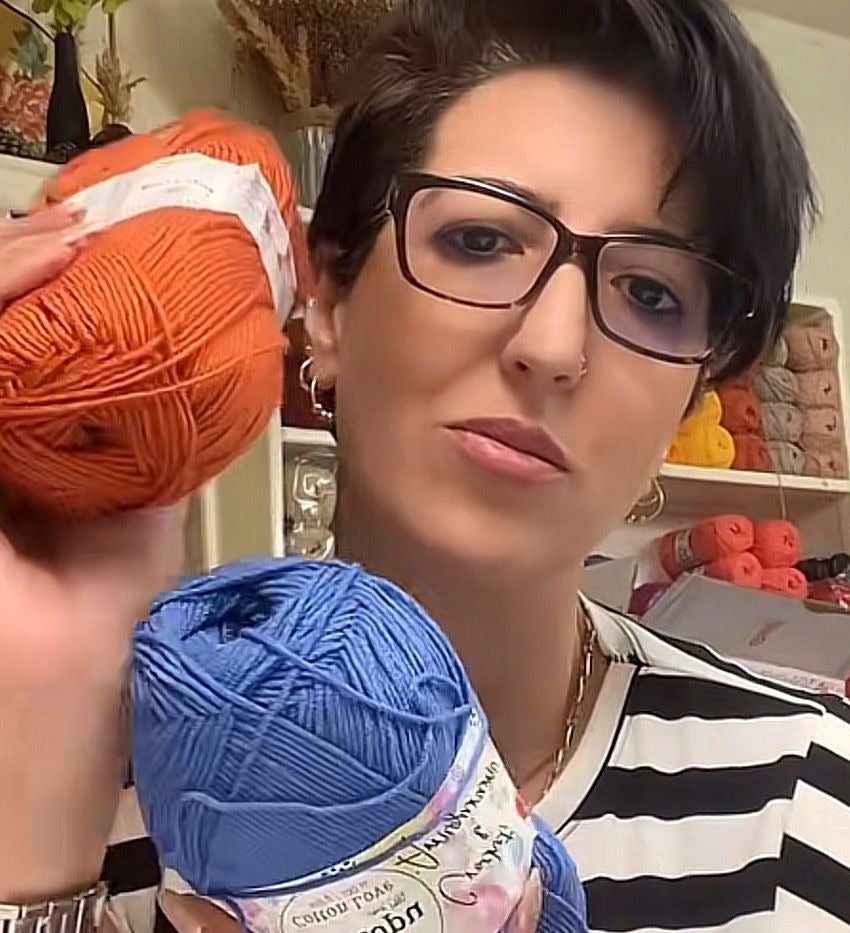 Asmahane Mostefai dans son atelier, deux pelotes de coton à la main